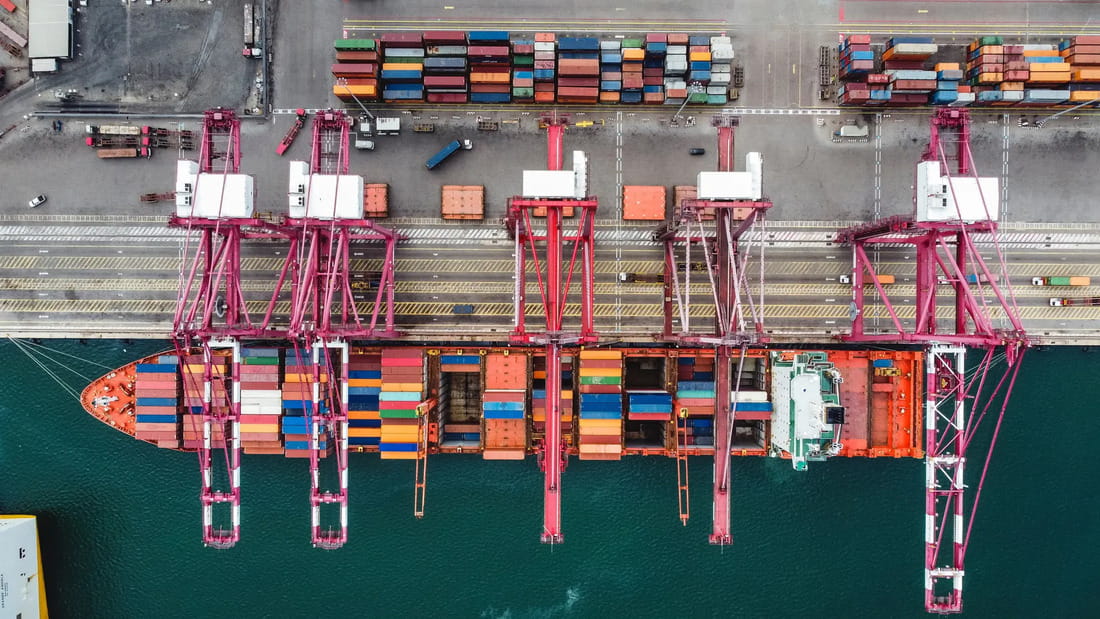  AGL ship being loaded with cargo while docked at a port.