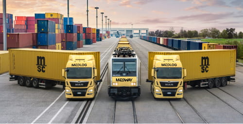 A MEDWAY freight train with two Medlog trucks carrying MSC-branded containers, highlighting integrated logistics and transportation services.