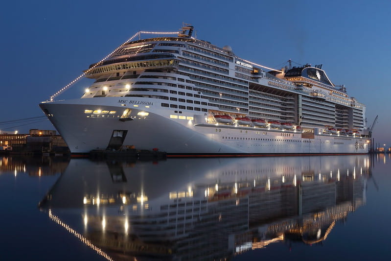 The MSC Cruises ship “MSC Bellissima” docked at the port at night,  embellished with lights.